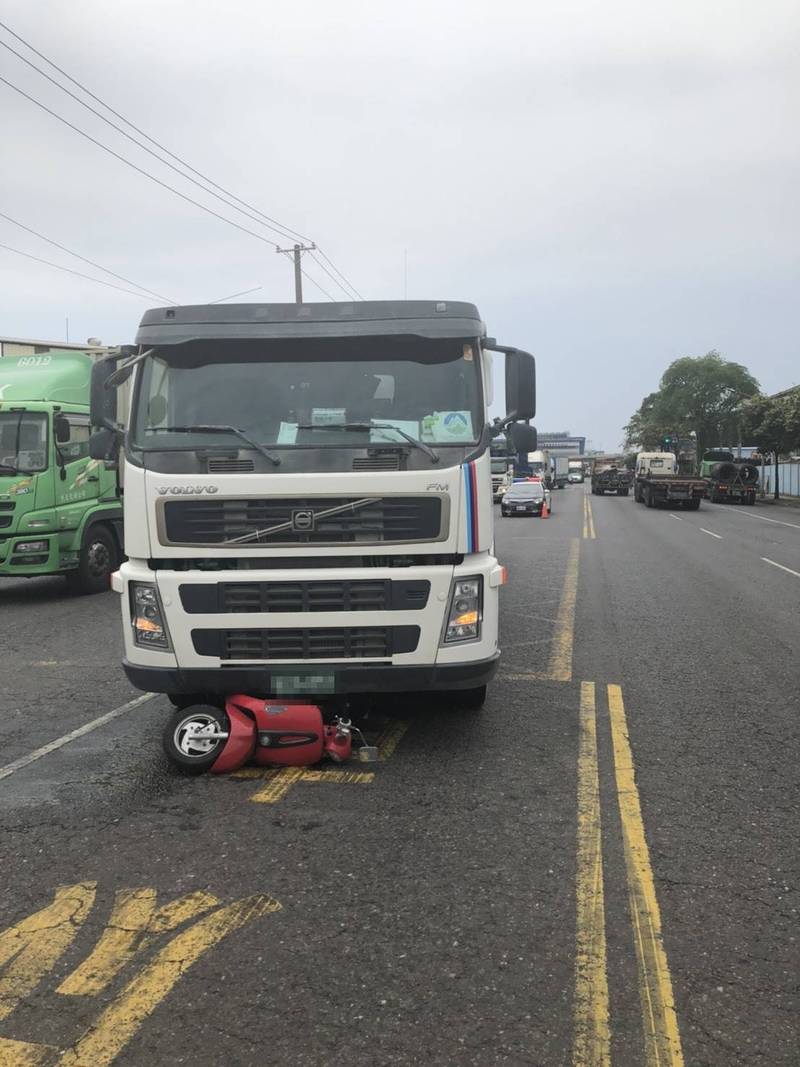 機車遭砂石車撞上,整輛機車被壓在砂石車底下,女騎士當場遭輾斃。(讀者提供) 機車遭砂石車撞上,整輛機車被壓在砂石車底下,女騎士當場遭輾斃。(讀者提供)