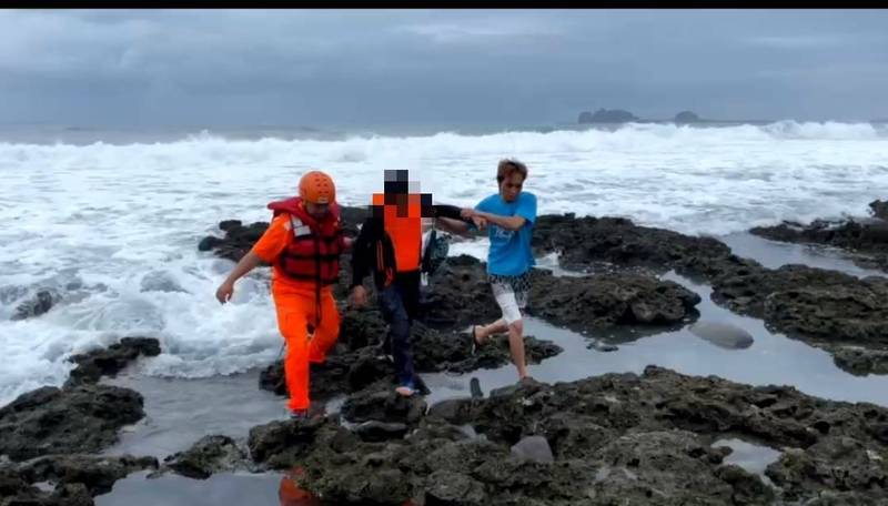 海巡人員偕民眾將落海船員救上岸。（記者陳賢義翻攝）