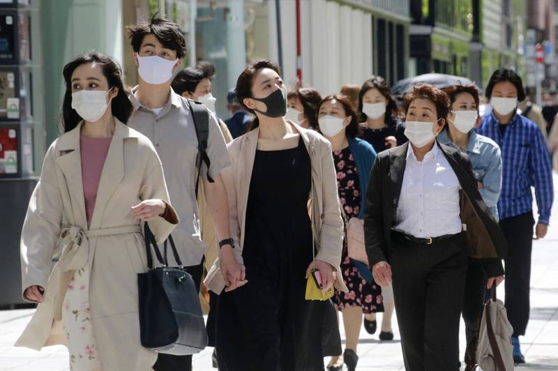 日本武漢肺炎疫情持續惡化，東京銀座鬧區街頭，行人都戴上口罩。（美聯社）