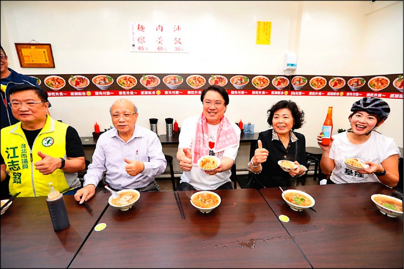 基隆市長林右昌（中）在松山吃「東發號」油飯及麵線，還自帶基隆醬料，讓美食感受再升級。（基隆市政府提供）