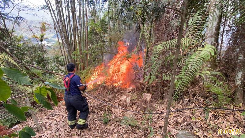 南投縣仁愛鄉中正村鄉道投70線上邊坡稜線中午發生山林火警，消防隊員獲報前往灌救。（記者佟振國攝）