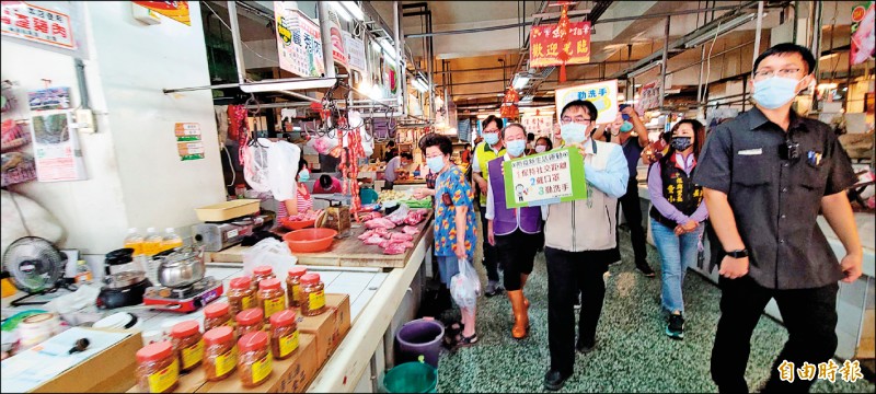 市長黃偉哲拿著手牌及麥克風，向北區開元市場內的攤商及採買民眾宣導防疫措施。（記者劉婉君攝）