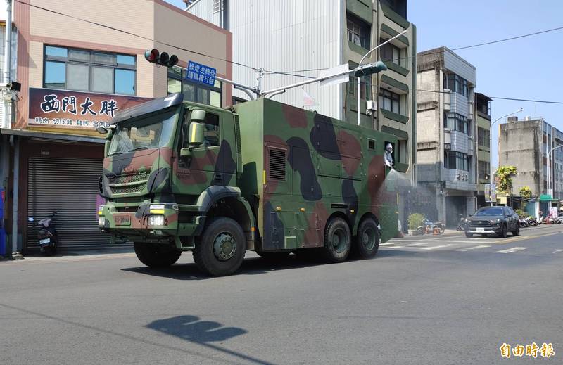 陸軍第十軍團36化學兵群偵消營進駐員林市消毒，重型車沿街噴灑漂白水。（記者陳冠備攝）