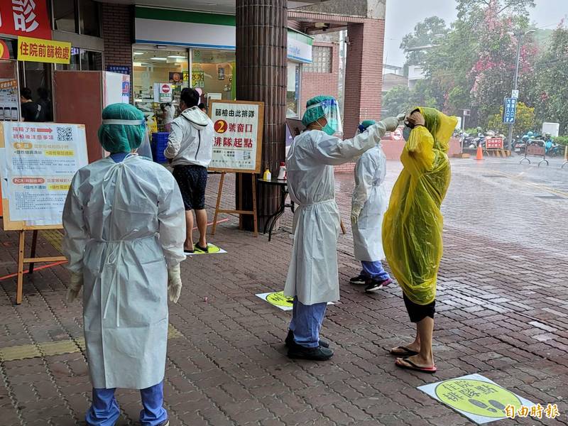 南投縣埔里鎮今天一口氣增加4人確診，衛生局也立即啟動篩檢服務，有民眾冒雨前做快篩。（記者佟振國攝）