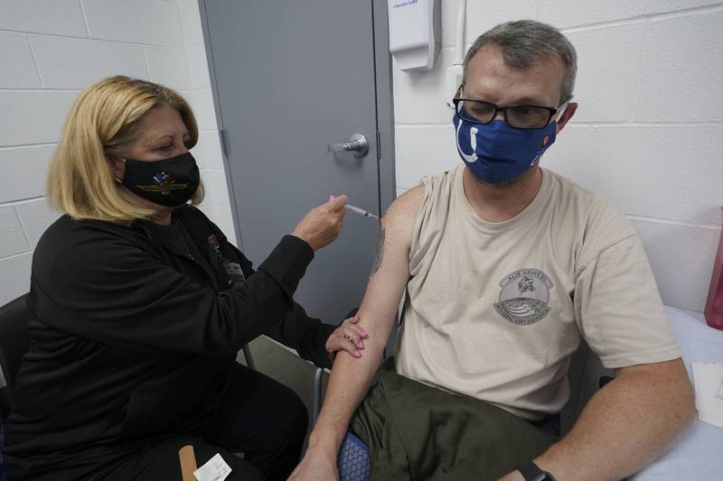 美國美國印第安納州首府印第安納波利斯（Indianapolis）的一名護理師，30日為民眾接種武漢肺炎疫苗。（美聯社）