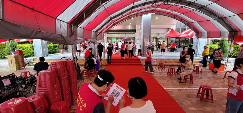 嘉義市今上午下大雨，港坪體育館外搭設棚架及紅地毯，讓家屬、長輩安心接種疫苗。（嘉義市政府提供）