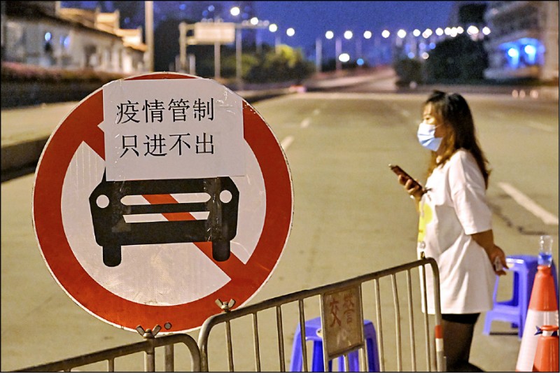 本月4日廣州市荔灣區芳村一條街道的交通標誌上，貼著因武漢肺炎疫情管制而「封村」的只進不出標語。（路透）