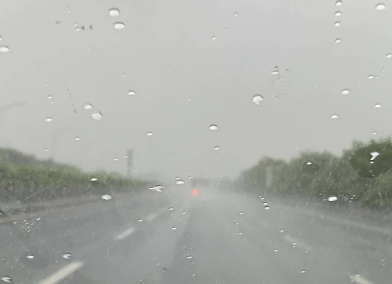 中部今天清晨一度傾盆大雨，上班族開車在國道1號高速公路能見度僅百餘公尺，紛紛打開大燈並放慢車速。 （記者湯世名翻攝）