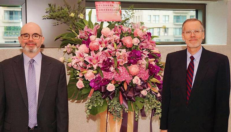 The Director of the American Institute in Taiwan Li Yingjie and Deputy Director Gu Liyan stood beside their taller flower baskets. The card of the flower basket reads 