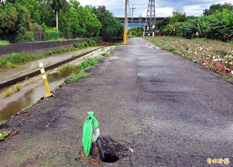 梅雨一波波來襲，南投市北通橋旁產業道路中間被淘空出現臉盆般大小的破洞。（記者謝介裕攝）