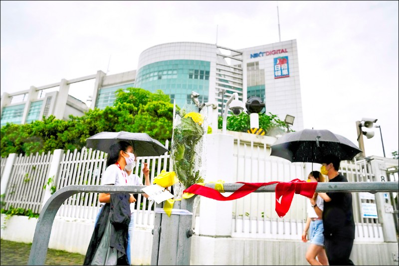 香港蘋果日報確定今天最後一次出刊後，結束26年歷史，該報電子版與香港壹週刊也同步停刊。圖為支持者昨冒雨在香港蘋果日報總部外聲援。（美聯社）