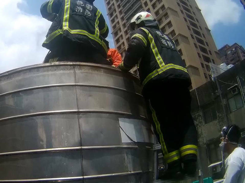 桃市警桃園分局埔子派出所昨天中午據報，鄰棟二樓頂的水塔內，疑似有人受困，警方立刻通知消防救難人員協助。（記者陳恩惠翻攝）