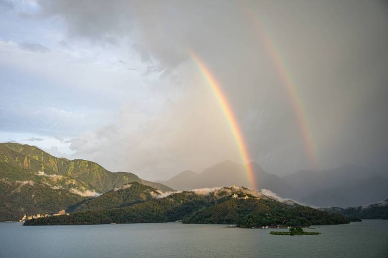 日月潭午後降雨，出現絢爛彩虹景致，加上雨滴夠大顆，在彩虹外圈的霓虹不僅明顯，景象也同樣精彩。（陳姓民眾提供）