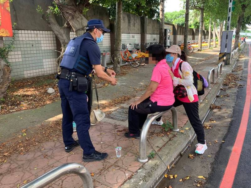 游姓婦人（中）微解封出遊，中暑癱坐路旁嚇壞同行友人，警察及時救援。（記者李容萍翻攝）