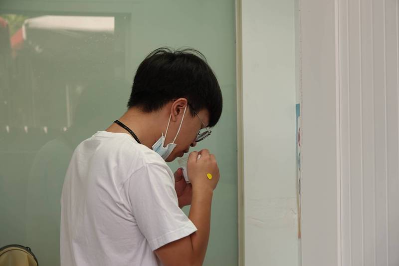 學生個別在採檢室自行將唾液滴入唾液盒。（圖由成大提供）