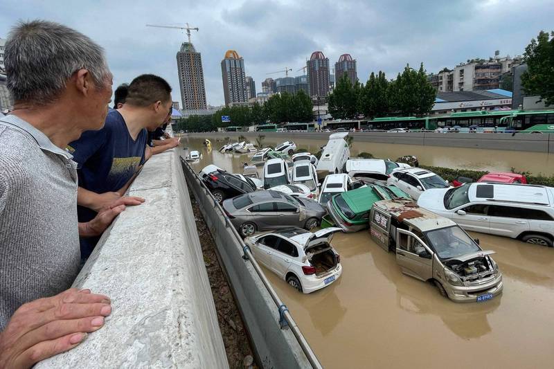 中国河南省郑州市一带上週以来大雨成灾，居民望着泡在水中的成堆车辆兴叹。（法新社）(photo:LTN)