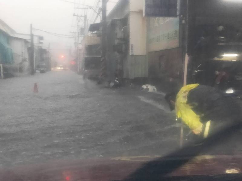 中央氣象局今天下午發布豪雨特報，新北市三重突降大雨，復興路、五華街口積水半公里長，交通一度受阻。（記者吳仁捷翻攝）