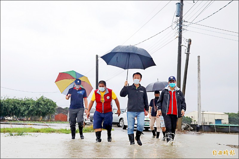 嘉義地區前天起至昨天持續降雨，嘉義縣長翁章梁（中）冒雨涉水勘查淹水情況。（記者蔡宗勳攝）