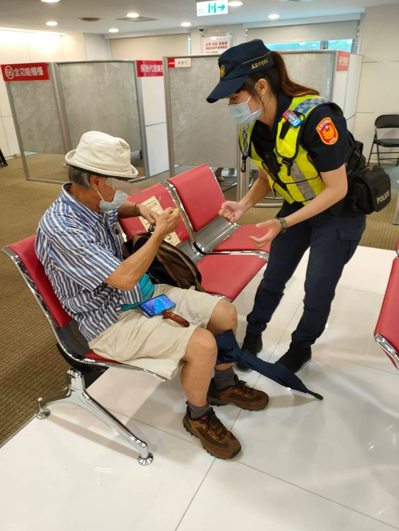 女警張捷瑜趕到銀行內，規勸吳翁先別匯款，並拿出相關新聞案例進行勸導（記者吳昇儒翻攝）