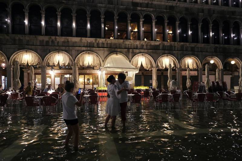 发生在8月9日的罕见夏季洪水破坏性较小，广场上的情侣随着公开演奏的钢琴曲，在及膝的水中翩翩起舞。（路透）(photo:LTN)