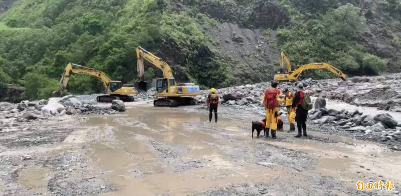 消防人員率搜救犬搜尋河道。（記者黃旭磊攝）