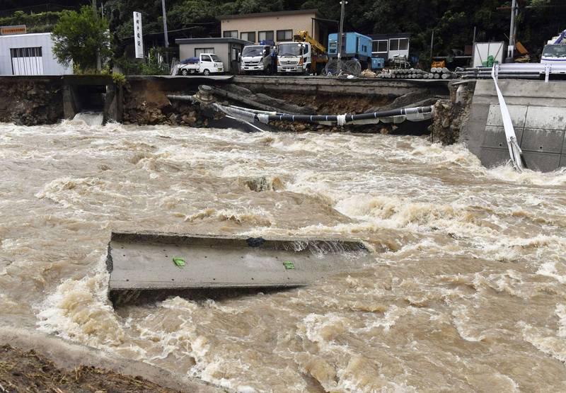 位在日本廣島西部的鈴張川（Suzuhari river）因為暴雨而導致河面水位暴漲，路面受損，而斷裂的路面就飄浮在土黃色的泥水上。（路透）