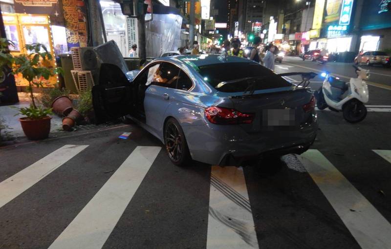 藍男駕駛的BMW撞毀夾娃娃機店前冷氣壓縮機。（記者張瑞楨翻攝）