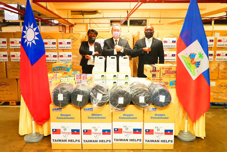 Vice Minister of Foreign Affairs Alexander Yui, center, and Haitian Charge d’Affaires in Taiwan Francilien Victorin, right, attend a ceremony in Taipei yesterday, marking Taiwan’s delivery of emergency supplies to Haiti.
Photo courtesy of the Ministry of Foreign Affairs