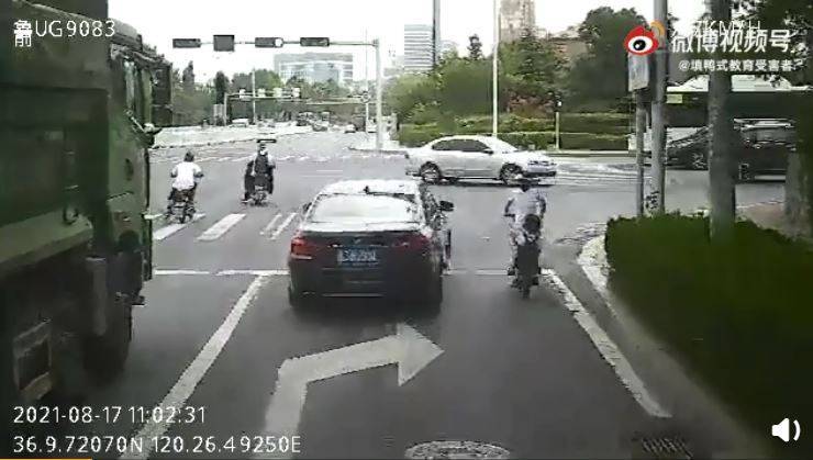 當時1名媽媽騎著電動車，後面載著年幼的孩子，遵守交通規則等紅燈。（圖擷取自微博）