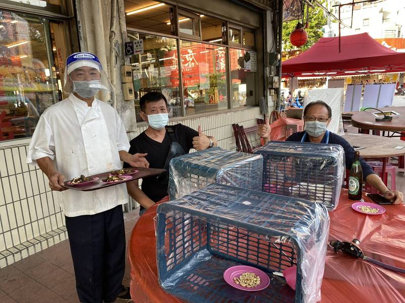 高雄知名老字號阿鳳台菜海產料理亭利用方型塑膠果菜藍當作隔板，老闆黃慶宗（左）自我打趣說：「有點粗魯，但很實用」。（圖黃慶宗提供）