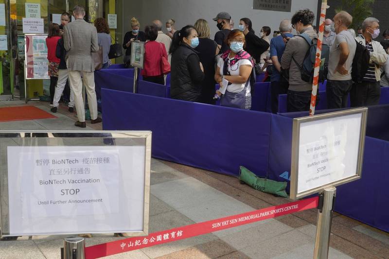 香港民众今年3月在疫苗接种中心外排队接种，中心告示写着辉瑞／BNT疫苗暂停接种。（美联社档案照）(photo:LTN)