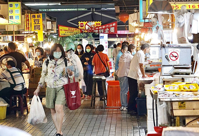 People shop at a wet market in Taipei yesterday. The Executive Yuan yesterday outlined its plans for a new stimulus voucher program, which it said would launch in early October and run until the end of April next year.
Photo: CNA