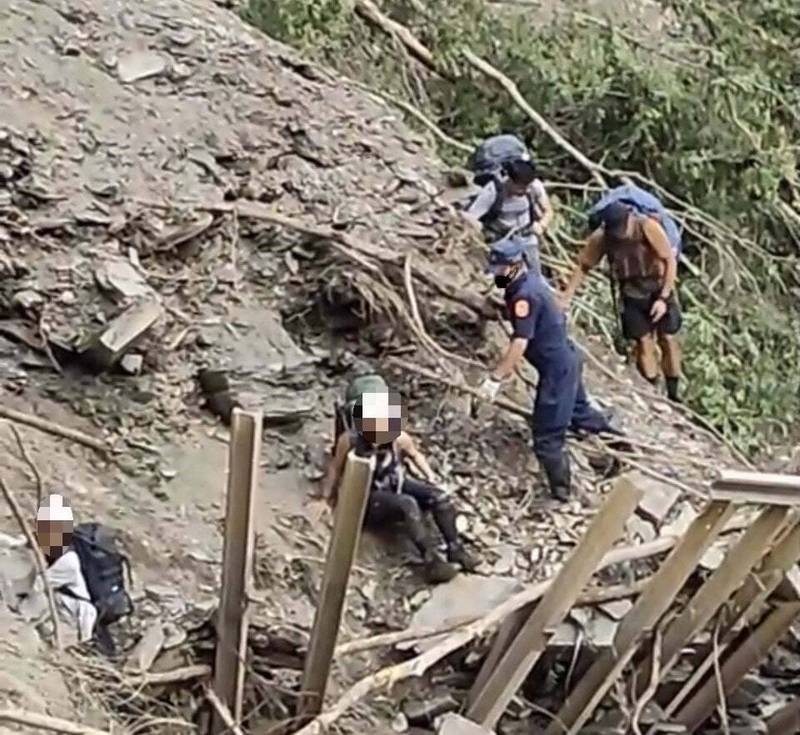 員警陪同登山客冒險穿越武界林道4.5K嚴重崩塌區。（仁愛分局提供）