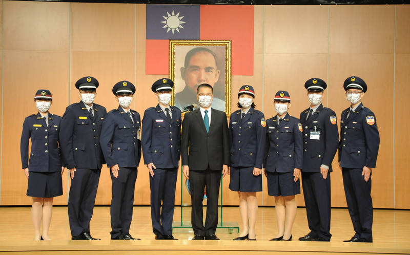 內政部長徐國勇（中）與年級章受頒學生代表合影。