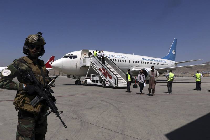 经营阿富汗国内航线的阿里亚纳阿富汗航空（Ariana Afghan Airlines）班机5日飞抵喀布尔机场，乘客陆续下机，停机坪还有神学士战士持枪戒护。（美联社）(photo:LTN)