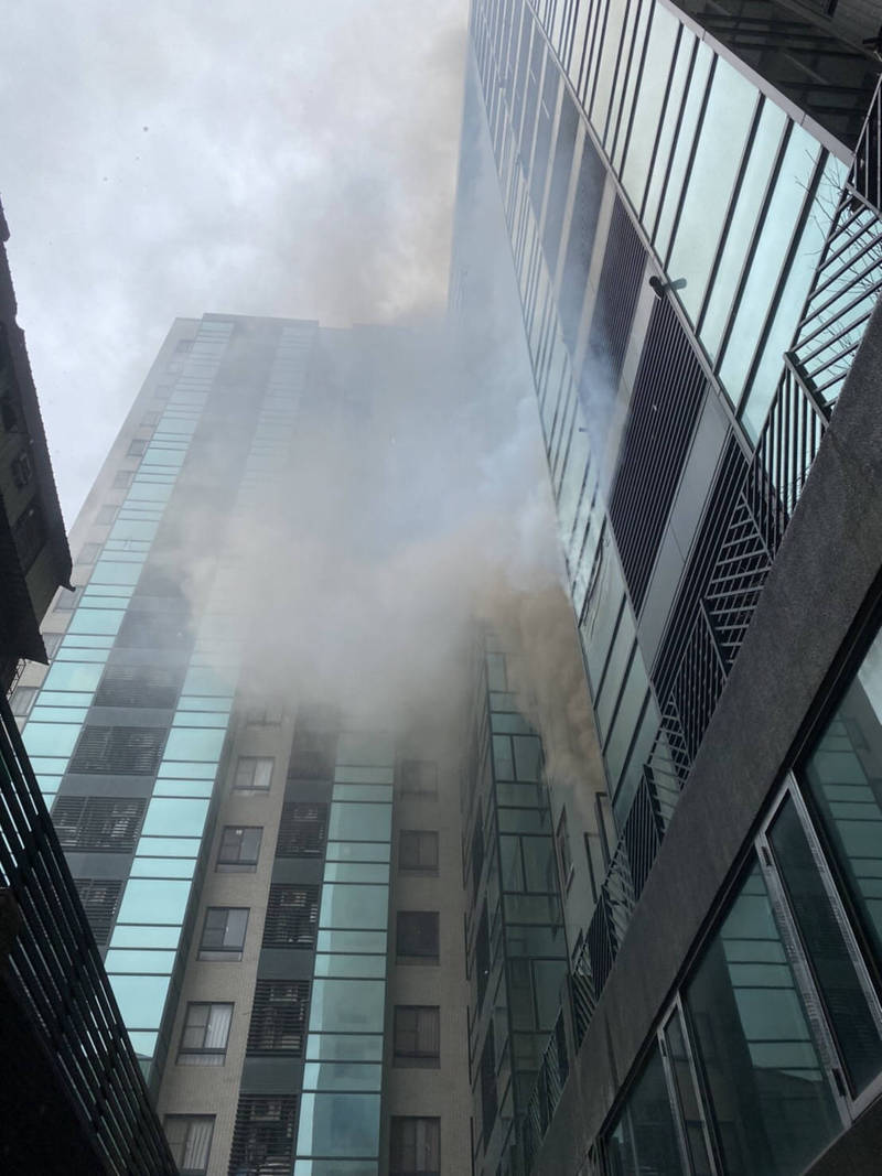 圖中大樓傳出火警，陣陣濃煙竄出。（圖由民眾提供）