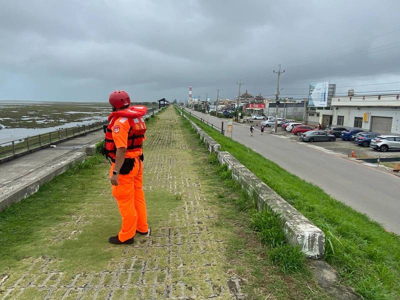 海巡署人員在高美濕地堤防上加強巡邏注意，以防遊客發生意外。（記者歐素美翻攝）