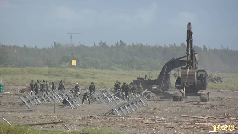 國軍工兵人員在台南南區鯤鯓海岸架設鋼刺蝟阻絕設施。（記者王俊忠攝）