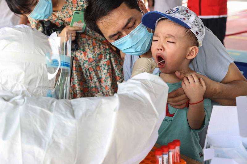 中國福建省疫情嚴峻，圖為廈門市一名兒童接受武漢肺炎篩檢。（法新社）