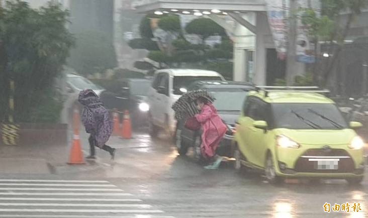 收假日屏東下起大雷雨，路上的行人快跑避雨。（記者葉永騫攝）