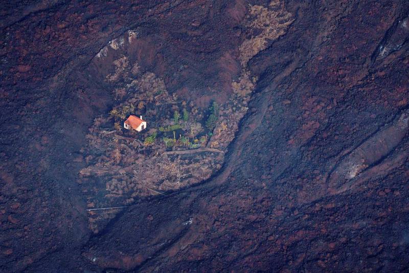西班牙加那利群島（Canary Islands）的拉帕瑪島（La Palma）上南部的老峰火山（Cumbre Vieja）於19日爆發，許多房屋都遭岩漿吞噬，卻有棟房子歷經浩劫後仍屹立不搖，被網友封為「奇蹟之屋」。（路透）