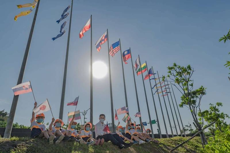 新竹漁港將6盟友國旗升上藍天，市長林智堅也與南寮國小學童一同舉起國旗合影，高喊「好朋友挺台灣！」（市府提供）