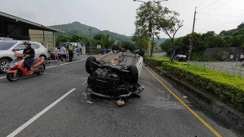 郭男載妻子上班途中，擦撞安全島，車頭向右甩飛，再撞路邊4輛轎車，最後在內車道翻車。（記者闕敬倫翻攝）