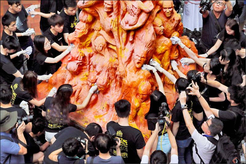 「国殇之柱」刻上身体扭曲、脸孔狰狞的人民，象征遭北京打压者。图为港大学生在二○一九年「六四」前夕洗刷雕塑。（美联社档案照）(photo:LTN)