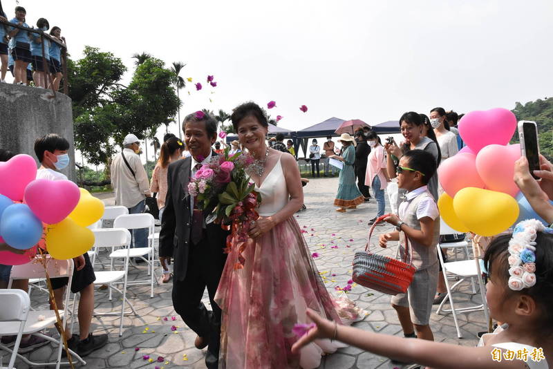 古坑華南社區今天舉辦紅寶石婚禮活動，平常擔任社區志工的阿公阿嬤穿上禮婚重溫當年婚禮，挽著另一伴的手笑得特別開心。（記者黃淑莉攝）