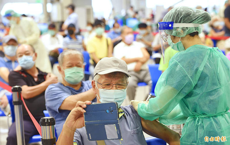 
A nurse vaccinates a man at the Expo Dome in Taipei yesterday.
Photo: Liu Hsin-de, Taipei Times