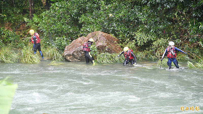 Rescuers yesterday search the Beishi River in New Taipei City’s Hubaotan area for missing people who were washed away by a flash flood.
Photo: Peter Lo, Taipei Times