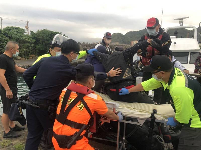 釣客及救護人員將鄭姓傷者抬上擔架。（記者吳昇儒翻攝）