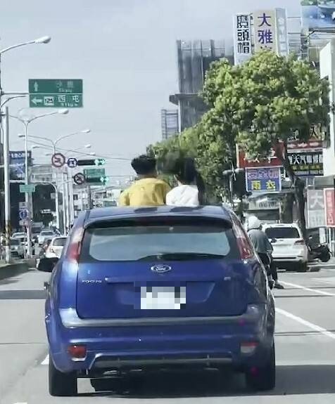 2名小朋友站在車上，上半身露在天窗外，警方表示，已違法。（圖擷取自記者爆料網）