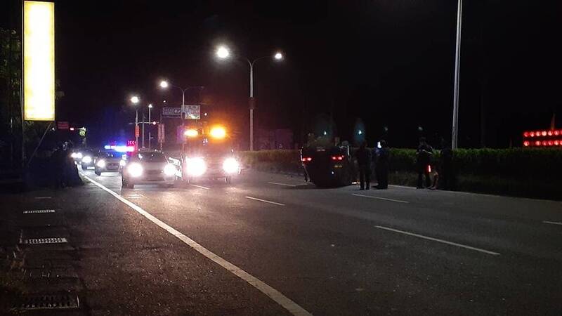 嫌犯意圖使用偽鈔加油見警巡邏車加速脫逃自撞分隔島翻車。（讀者提供）